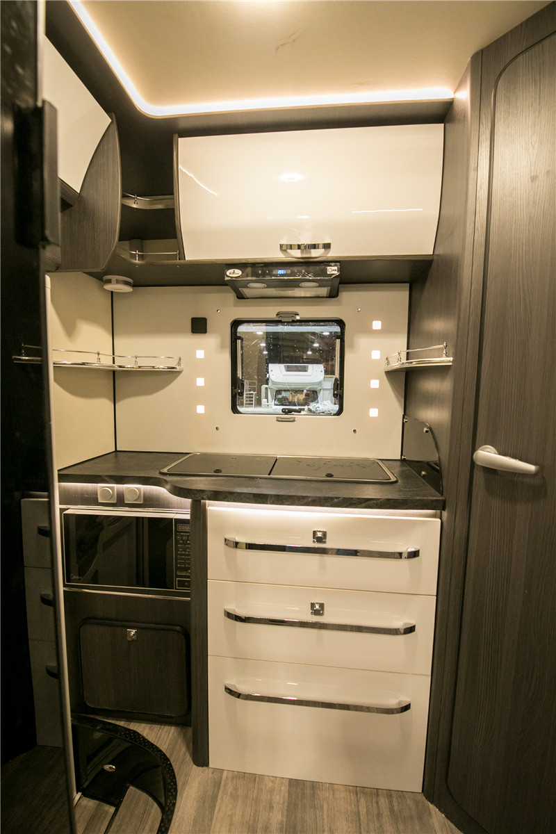 厨房位于车厢后侧,配备有储物柜,微波炉,油烟机,燃气灶,带盖水槽,冰箱